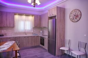eine Küche mit Kühlschrank und einem Tisch mit Stühlen in der Unterkunft Sofia Xara House in Agios Kirykos