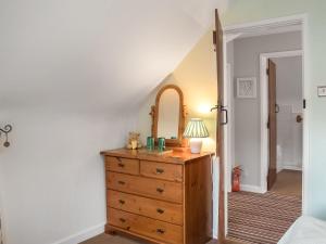 a bedroom with a dresser and a mirror at Apple Blossom Cottage - Uk46648 in Cheddar +2 photos