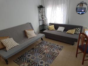 - un salon avec deux canapés et un tapis dans l'établissement 2º Apartamento 3 hab 15' Barcelona centro y 8' Playa caminando, à Sant Adrià de Besòs