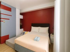 a bedroom with a bed with two blue slippers on it at Stylish Urban in Central Location with 500Mbps WiFi and Private Parking in Bacolod