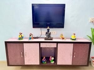 斋浦尔Highway access 2BHK, Trendy decor, VR & other water parks的电视柜前摆放着小雕像