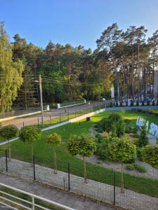 a park with trees and bushes in a park at Apartament Arbuzowy Zachód Słońca in Pobierowo