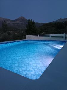 a swimming pool with blue water with mountains in the background at Los Cabales in Torres