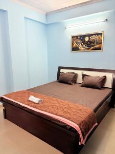 斋浦尔Highway access 2BHK, Trendy decor, VR & other water parks的一张大床,位于拥有蓝色墙壁的房间