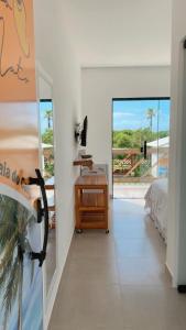 a bedroom with a desk and a bed and a balcony at POUSADA CAJU DO MATO in Prado +55 photos