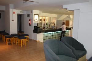a man standing at a counter in a bar at Cheerfulway Minichoro Apartamentos in Albufeira