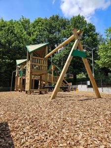 a small playground with a wooden play structure at 't Grote Egeltje XL chalet 220 in Durbuy