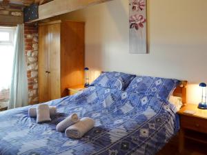 a bedroom with a blue bed with towels on it at Kittiwake House in Flamborough