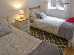 a bedroom with two beds and a table with a lamp at Number 7 in Whitby +2 photos