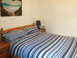 a bed with a blue and white striped comforter in a bedroom at Loch Ness - Uk7094 in Contin