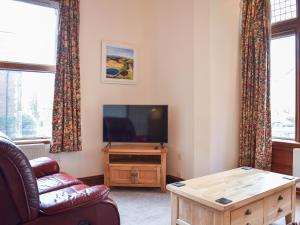 a living room with a tv and a couch and a table at Inglewood Terrace in Penrith