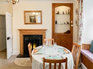 a dining room with a table and a fireplace at Atlantic House - 27665 in Port Isaac