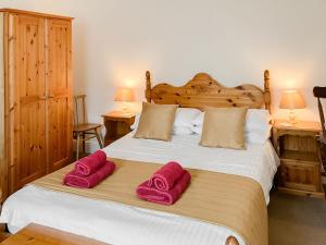 a bedroom with a bed with two pink towels on it at Atlantic House - 27665 in Port Isaac +12 photos