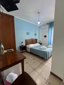 a bedroom with a bed in a room with blue walls at Hotel Giglio in Lampedusa