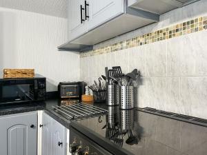 a kitchen with a counter top with a microwave at Lake View Cottage in Belper