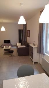 una sala de estar con un sofá y una mesa en Colombe, en LʼIsle-sur-la-Sorgue