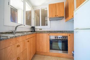 a kitchen with wooden cabinets and a sink at Torrebaix in Torredembarra +1 photo