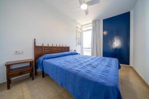 a bedroom with a blue bed with a blue comforter at Torrebaix in Torredembarra