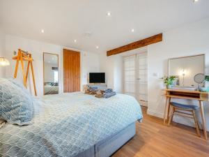 a bedroom with a bed and a desk and a television at Horseshoe Cottage - Uk48252 in Downderry +9 photos
