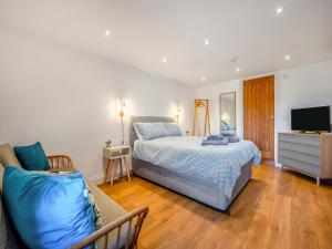 a bedroom with a bed and a tv and a couch at Horseshoe Cottage - Uk48252 in Downderry
