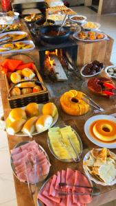 a table filled with different types of food on plates at POUSADA CAJU DO MATO in Prado