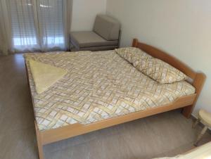 a bedroom with a bed and a chair in a room at Adriatic Sunset House in Petrovac na Moru
