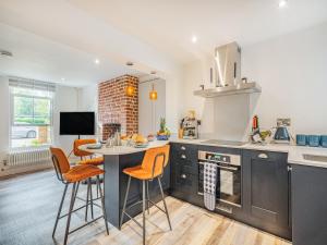 een keuken met een aanrecht en een tafel met stoelen bij Lavender Cottage in Coltishall