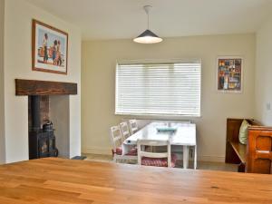 une salle à manger avec une table et une cheminée dans l'établissement Riverbank Cottage, à Althorpe