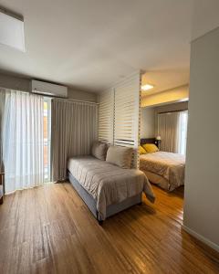 una camera con due letti e un divano in camera di Syrah Suites a Buenos Aires