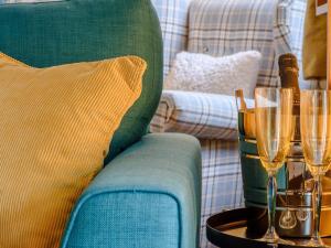 a green couch with champagne glasses on a table at Cherry Tree Corner in Ashbourne