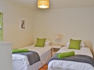 - 2 lits dans une chambre avec des oreillers verts dans l'établissement Riverbank Cottage, à Althorpe 8 autres photos