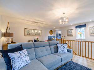 a living room with a blue couch and a kitchen at Lindale Cottage in Skipton