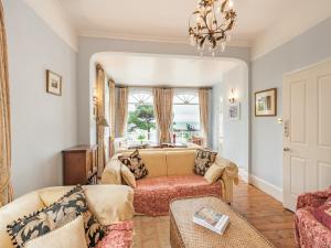 a living room with a couch and a chandelier at The Cottage in St Margarets at Cliff