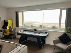 a living room with a pool table in front of a window at Seaview House in Thornton