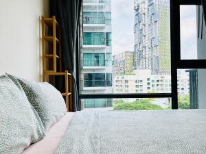 een slaapkamer met een bed en een groot raam bij Rhythm sukhumvit 36 two bedrooms in Bangkok