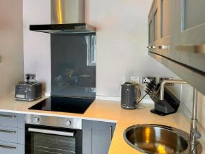una cocina con fregadero y estufa en The Hydaway, en Bowness-on-Windermere 14 fotos más