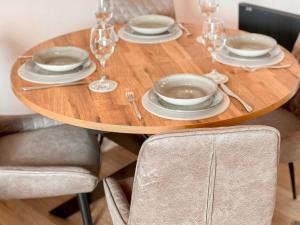 Una mesa de madera con platos y copas de vino encima. en The Hydaway, en Bowness-on-Windermere