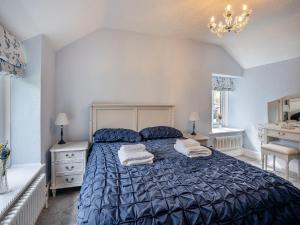 a bedroom with a blue bed with towels on it at Miners Arms Cottage in Stepaside +14 photos