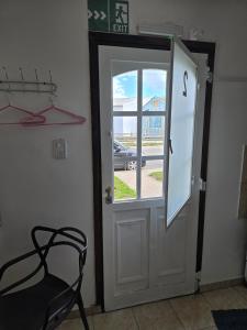 a black chair next to a door with a window at Aparts Valentyna El Chalten 2 in El Chalten