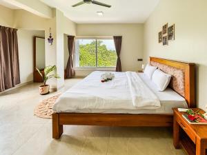 a bedroom with a large bed and a window at 5 Star Luxe 2BHK River View Apartment Porvorim in Porvorim
