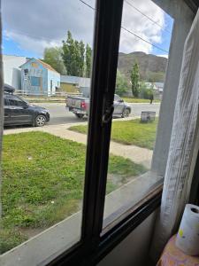 a window with a view of a street with cars at Aparts Valentyna El Chalten 2 in El Chalten +31 photos