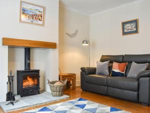 a living room with a couch and a fireplace at Pilchard Cottage in Scarborough