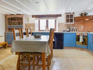 a kitchen with blue cabinets and a table with chairs at The Imaginary Barn in Hartland