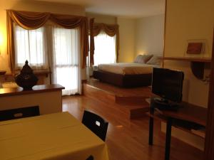a bedroom with a bed and a desk with a television at Casa Palladio 29 in Verona