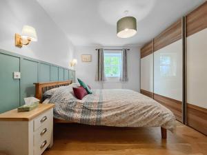 a bedroom with a bed with a wooden headboard at Copper Cottage in Atworth