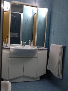 W łazience znajduje się umywalka i lustro. w obiekcie Casa Palladio 29 w Weronie