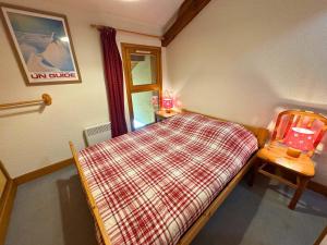 a small room with a bed and a chair at Duplex classique 6 pers à 50m du télécabine, 2 chambres - FR-1-452-139 in Saint-Martin-de-Belleville