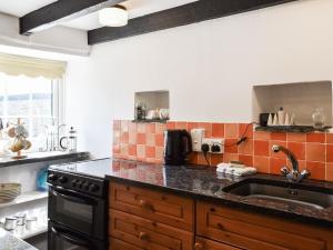 a kitchen with a sink and a counter top at Barn Cottage - Uk47089 in Davidstow