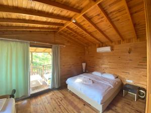 a bedroom with a bed in a wooden room at Kadir's Eco Life in Kumluca
