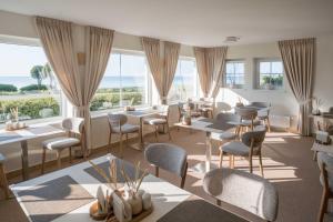 a restaurant with tables and chairs and windows at Prie Marių Nida in Nida